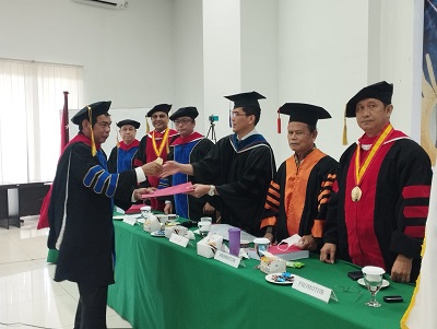Dr Layari Sinukaban MTh saat menerima hasil disertasinya yang diserahkan Ketua Sidang Dr Endro Tobing MHum disaksikan Sekretaris Dr Suardin Gaurifa MTh, Promotor Dr Ir Ferlin Zebua MM, Dr Robert Benediktus MA MTh, Prof Dr Benyamin Situmorang, Penguji Dr Stevanus Liong MTh dan Dr Saur Hasugian MTh, dalam sidang terbuka promosi doktoral yang dilaksanakan di STTPK GBI Rumah Persembahan Sumatera Resort Jalan Jamin Ginting Simpang Selayang Medan, Rabu (5/4/2023). Waspada/Ist