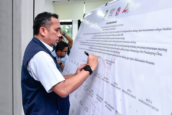 Pj. Waki Kota Sabang, Reza Pahlevi menandatangani komitmen bersama di spanduk ukuran besar. (Waspada/ist.)