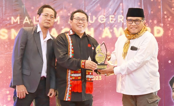 Ketua SMSI Pusat Firdaus, didampingi Ketua SMSI Aceh Aldin Nainggolan menyerahkan penghargaan kepada Pj Bupati Pidie Ir Wahyudi Adisiswanto M.Si, sebagai Tokoh Rekonsiliasi dan Pembangunan, pada malam Anugerah SMSI Aceh Award (SAA) 2023 di Parkside Gayo Petro Hotel, Takengon, Aceh Tengah, Senin (8/5). Waspada/Ist