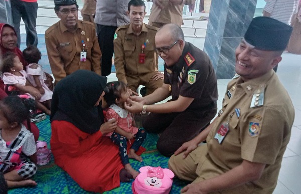 Pj Wali Kota Lhokseumawe Imran dan Kepala Kejaksaan Negeri Lhokseumawe Lalu Saifuddin, Selasa (9/5), asuh dan manjakan anak-anak stunting dengan menu bergizi dari pangan lokal di Gampong Jawa Kec. Banda Sakti. Waspada/Zainuddin Abdulah