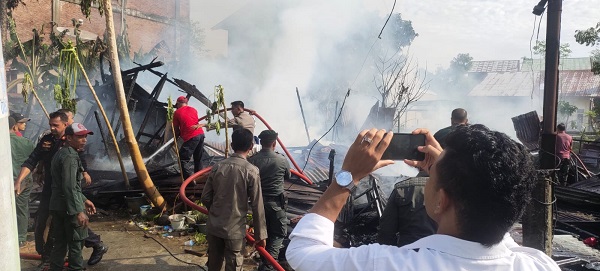 Petugas pemadam kebakaran dibantu oleh warga berupaya memadamkan api yang membakar dua unit rumah di Desa Kampung Jawa Baru, Kecamatan Banda Sakti, Kota Lhokseumawe, Senin (15/5). Waspada/ist