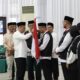 Sekda Pidie H.Idhami, S.Sos, MSi menyerahkan Bendera Merah Putih kepada petugas kloter 02 di Aula Jeddah Asrama Haji Aceh, Rabu (24/05/23) malam. (Waspada/T.Mansursyah)