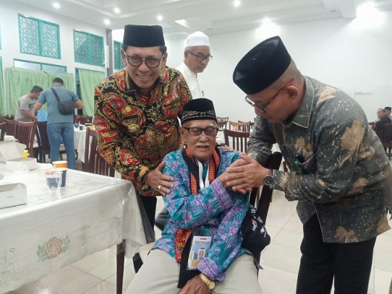 Ketua petugas PPIH Embarkasi Aceh yang juga Kakanwil Kemenag Aceh Azhari menyalami calhaj tertua Aceh Muhammad Taher (umur 100 tahun) disela-sela pemberangkatannya di Asrama haji embarkasi Aceh, Senin (29/05/23). (Waspada/T.Mansursyah)