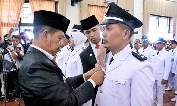 Bupati Simalungun, Radiapoh Hasiholan Sinaga, menyematkan tanda jabatan kepada salah seorang pangulu yang dilantik di Balei Harungguan Djabanten Damanik, Kantor Bupati Simalungun, Pamatang Raya, Rabu (07/06).(Waspada/ist).