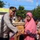 KAPOLRES Dairi AKBP Wahyudi Rahman (kiri) menyerahkan bantuan sembako kepada masyarakat di Dairi.Waspada/ist.