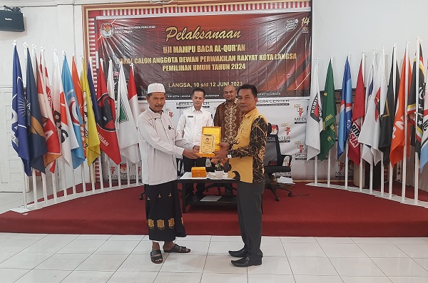 Ketua KIP Kota Langsa, T Faisal SH, saat menerima berkas uji mampu baca Alquran para Bacaleg dari tim penguji, di Aula KIP Langsa, Selasa (12/6) malam. Waspada/Rapian.