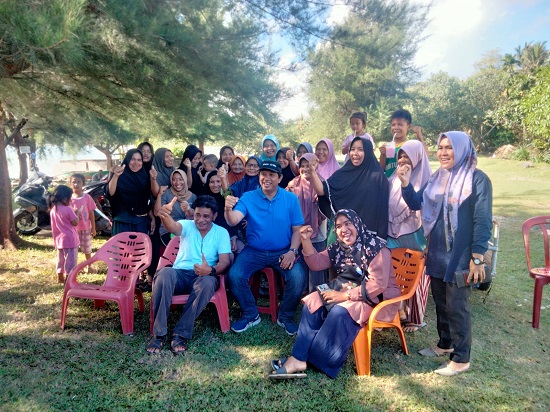 Tengah pakai baju biru dan topi pet, Fuadri, M Si foto bersama dengan sejumlah PKK di Pantai Nasrehe, Simeulue. Minggu lalu. Dok Waspada/Rahmad.