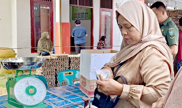 SEMBAKO- Seorang ibu warga Kecamatan Mutiara, Kabupaten Pidie sedang antre untuk membeli sembako yang dijual murah oleh Disperindagkop -UKM, Kabupaten Pidie di Halaman Kantor Camat Mutiara, Rabu (7/6) Waspada/Muhammad Riza