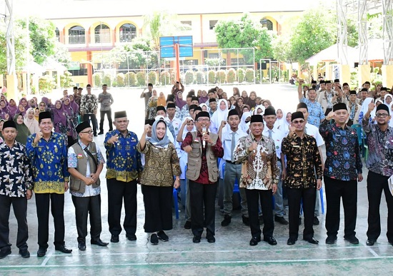 BUPATI Deliserdang H.Ashari Tambunan (4 kanan) didampingi Ketua Baznas Deliserdang H.Surya Putra (5 kanan) dan lainnya usai menyerahkan zakat, infaq dan shadaqah kepada siswa Madrasah di MAN 2 Deliserdang, Kamis (15/6). (Waspada/Khairul K Siregar/B)