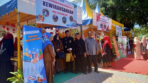 Kepala SMAN 2 Abdya, Abu Bakar S.Ag, dengan menggunakan pakaian adat Aceh, meninjau stand expo karya seni siswa-siswi. Senin (19/6).Waspada/Syafrizal