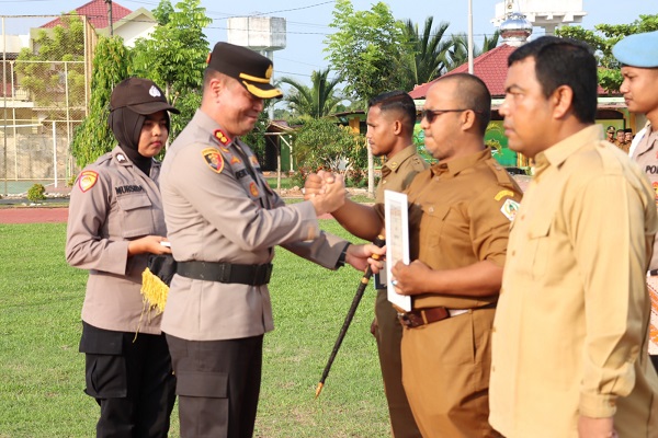 Kapolres Aceh Utara, AKBP Deden Heksaputera S, S.I.K, menyerahkan piagam penghargaan dan hadiah kepada tiga pemenang lomba pos Satkamling tingkat Polres, Rabu (21/6). (Waspada/ist)