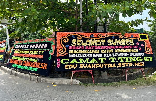 Karangan bunga papan ucapan selamat sukses atas pengungkapan kasus pembunuhan terpampang di depan Polres Tebingtinggi, Jalan Pahlawan. Waspada/Kristian Brahmana