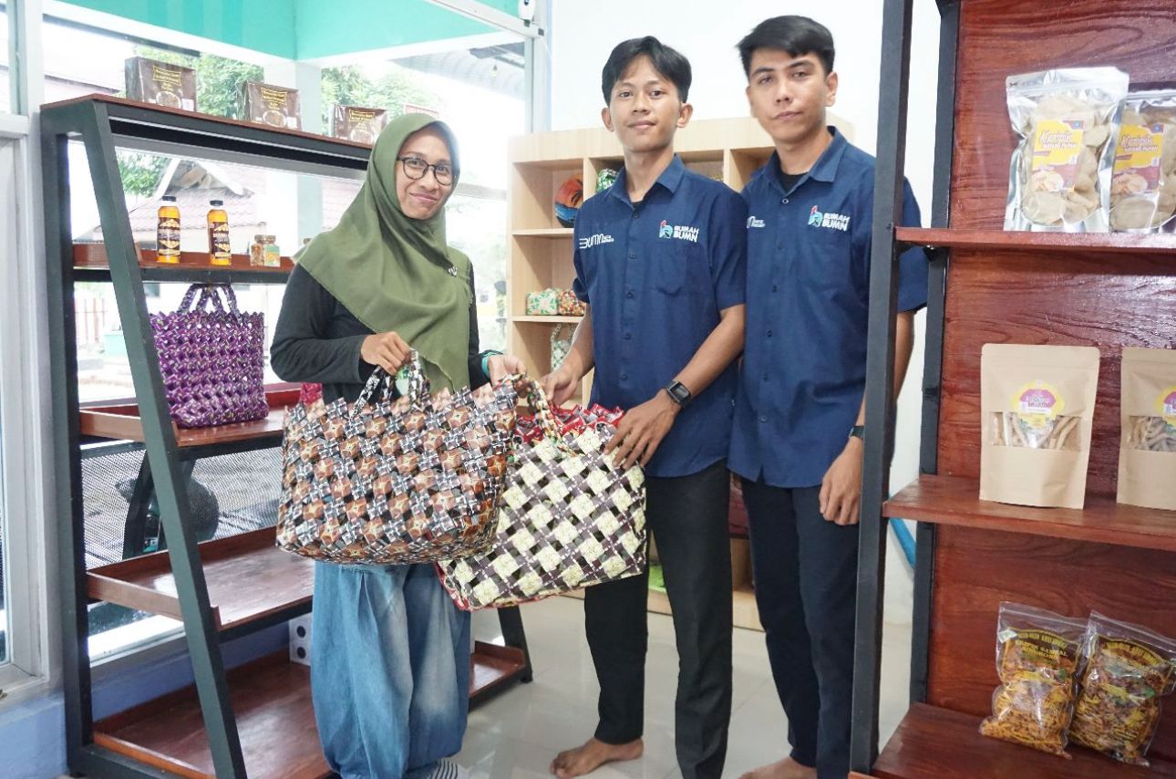 Salah satu masyarakat Kota Sibolga (kiri) membeli tas tangan yang terbuat dari sampah plastik bersama petugas rumah BUMN Sibolga.