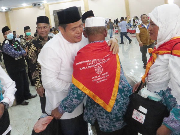 TERHARU: Wakil Bupati Labusel Ahmad Padli Tanjung terharu menyambut kepulangan jemaah haji Kloter 20 di Asrama Haji Medan, Selasa (25/7). Waspada/Surya Efendi