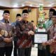 KEPALA Kantor Wilayah Kementerian Agama Provinsi Sumatera Utara H. Ahmad Qosbi, S.Ag, MM di idampingi Kabid Penmad Erwin Dasopang memberi penghargaan untuk kepala madrasah. Waspada/ist