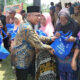 ANGGOTA DPRD Sumut Rudi Alfahri Rangkuti, menyerahkan bantuan sembako kepada warga lanjut usia (lansia) di Kecamatan Hinai, Kabupaten Langkat, Minggu (30/7). Waspada/Ist