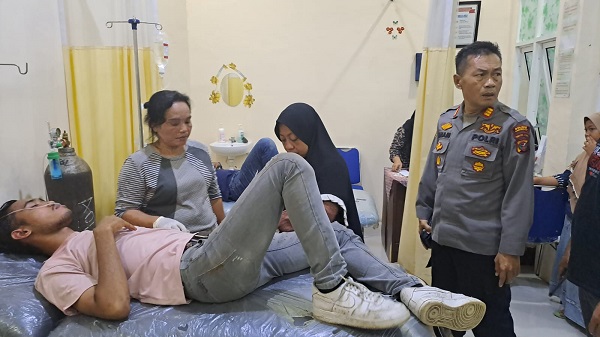 Kapolsek Kuala AKP Ilham melihat salah satu korban terluka pascabentrok IPK dan FKPPI di Kuala. (Waspada/ist)