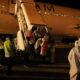 Petugas embarkasi haji Aceh sedang membantu jamaah haji kloter 06 yang baru tiba di Bandara SIM Aceh Besar, Senin (10/07/23) dini hari. (Waspada/Ist)