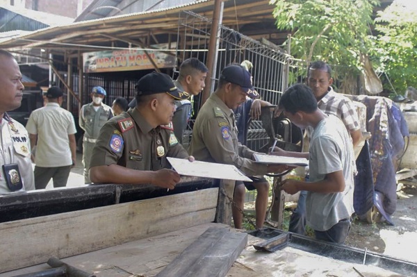 Personel Satpol PP Aceh Besar memberikan surat teguran ketiga kepada pemilik bangunan liar atau kios liar yang berada didepan toko dan di atas irigasi disepanjang jalan Muhammad Hasan, Darul Imarah, Aceh Besar, Rabu (12/7). (Waspada/Zafrullah)