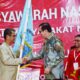 Ketua MPO, Yasonna H Laoly menyerahkan bendera pataka kepada Ketua Umum HIMNI terpilih, Yaatulo Gulo, Jumat (14/7) malam. Waspada/Ist