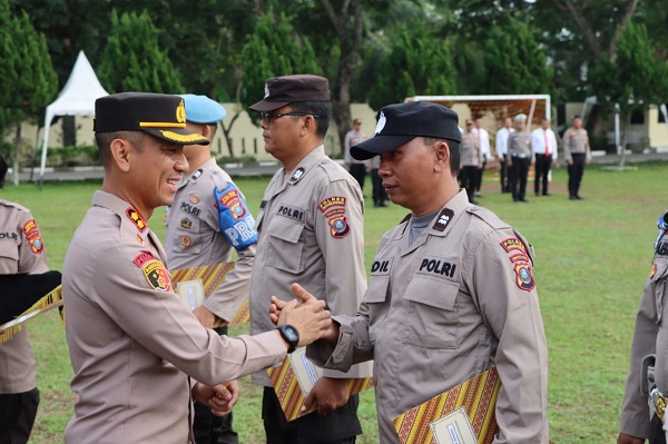 Kapolres Sergai AKBP Oxy Yudha Pratesta SIK saat menyerahkan piagam penghargaan kepada personel Polres Sergai yang berprestasi, Senin (17/7) di halaman Mapores Sergai di Sei Rampah.(Waspada/Ist)