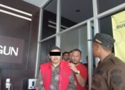 Oknum PM mantan Pangulu Bahung Kahean, menggunakan rompi merah saat digiring dari kantor Kejari Simalungun, Jumat (21/7).(Waspada/ist).