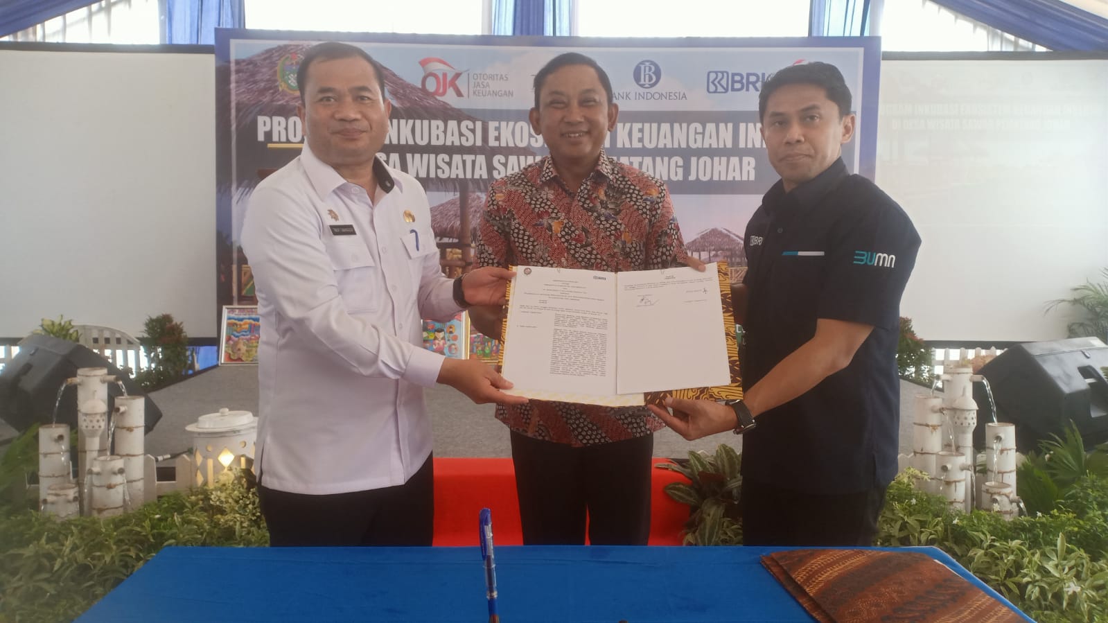 Penandatanganan MoU antara Sekda Kabupaten Deli Serdang Timur Tumanggor dan Regional CEO BRI Medan Aris Hartanto, disaksikan Kepala OJK Regional 5, Bambang Mukti Riyadi, pada acara Program Inkubasi Ekosistem Keuangan Inklusif di Desa Wisata Sawah Pematang Johar, Kabupaten Deli Serdang, Rabu (9/8).