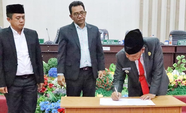 Bupati Simalungun Radiapoh H Sinaga, menandatangani berita acara persetujuan Ranperda menjadi Perda di ruang sidang paripurna DPRD Simalungun di Pamatangraya, Senin (31/7).(Waspada/ist).