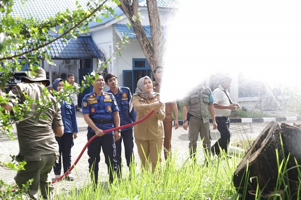 Wabup Madina Atika Azmi Utammi Nasution mencoba menyiram menggunakan mobil damkar mini yang diserahkan ke Satpol PP dan Damkar Madina. Waspada/Ist