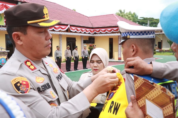 Kapolres Simalungun, AKBP Ronald FC Sipayung, menyematkan tanda kepada salab seorang personel Polisi RW pada acara Apel dan Launching Polisi RW di Mako Polres Simalungun di Pamatangraya, Senin (21/8).(Waspada/ist)
