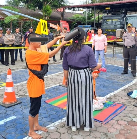 KEDUA pelaku saat memerankan adegan pembunuhan di halaman Mapolres Tanah Karo. Waspada/ Micky Maliki.