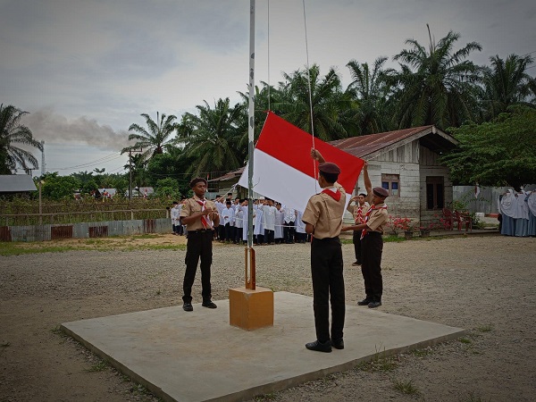 Santri Ponpes Al Hidayah sedang mengibarkan bendera merah putih pada upacara peringatan hari Pramuka tahun 2023 yang berlangsung Senin (14/8) di Ponpes tersebut. (Waspada/Yusri).