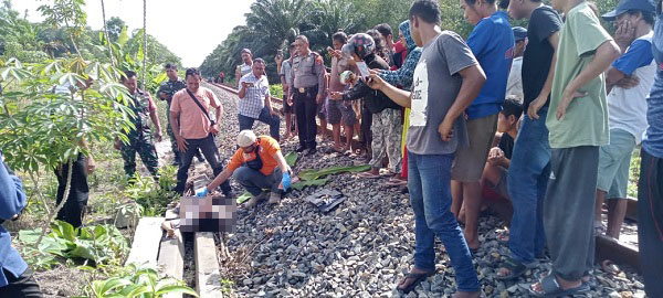 Petugas dan masyarakat mengevakuasi korban dari lintasan kereta api Jalur Kereta Api Km. 37 - 300 Peta Jalan Siantar - Tebing Tinggi, Huta I Purbasari Nagori Purbasari Kec.Tapian Dolok, Selasa (15/8).(Waspada/ist).
