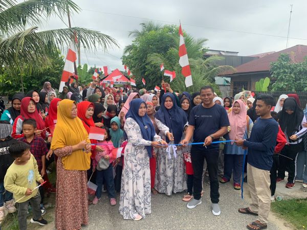 Geuchik Gampong Sungai Pauh, Aguslim Tanjung beserta ibu saat melepas ratusan peserta gerak jalan santai pada peringatan HUT ke-78 RI, di Dusun Satria, Kamis (17/8). Waspada/Rapian