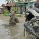 Salah seorang warga Desa Pematang Seibaru, Kec Silaulaut, Kab Asahan mandi lumpur di jalan utama desa yang masuk dalam proyek strategis Pemprov Sumut dengan total anggaran Rp2,7 T yang sampai kini di Asahan belum maksimal dikerjakan. Waspada/Bustami Chie Pit