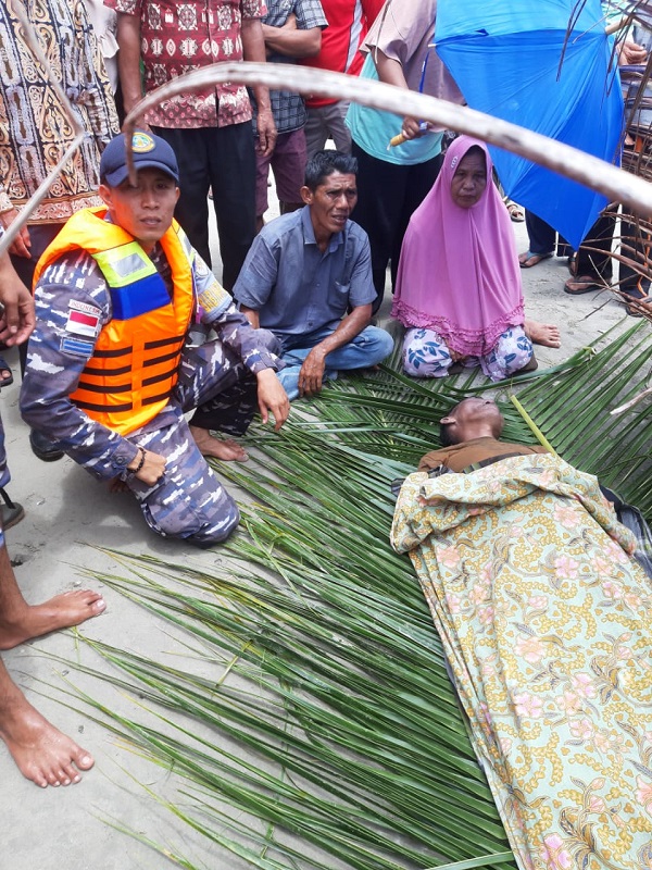 Jenazah Hasnal Ami dibaringkan sementara di atas daun nyiur di pantai usai dievakuasi dari laut, Kamis (24/8). Waspada/ist