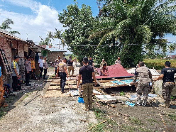 Muspika Seirampah dan Satpol PP Pemkab Sergai tampak gotong royong membantu korban bencana puting beliung di Dusun V Desa Pematang Pelintahan, Rabu (23/8) kemarin. (Waspada/Edi Saputra)