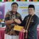 KPW BI Aceh Rony Widijarto menyerahkan buku petunjuk Qris kepada Plh Asissten Administrasi Umum Edy Widodo, saat sosialisasi Gerakan Cinta Rupiah, di Oprrom Kantor Bupati, Kamis (24/8). WASPADA/Ariefh