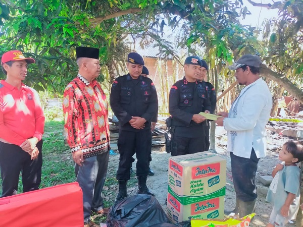 Personel Brimob Kompi 2 Batalyon B Pelopor Aramiyah Polda Aceh saat menyerahkan bantuan peduli terhadap korban musibah kebakaran, Saifuddin, 40, warga Dusun Tripida, Gampong Tualang Teungoh, Kecamatan Langsa Kota, Jumat (25/8). Waspada/Rapian