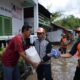 ANGGOTA DPRD Sumut Ahmad Darwis (tengah) memberikan bantuan kepada warga terdampak banjir di Kelurahan Sei Mati, Kecamatan Medan Maimun, pekan lalu. Waspada/Ist