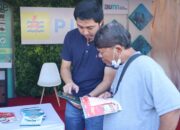 Petugas PLN sedang menjelaskan kepada pelanggan cara mendapatkan voucher tambah daya listrik melalui aplikasi PLN Mobile saat event Medan Independence Day Festival 2023.