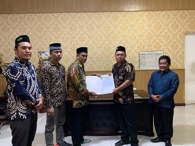 KETUA LPBHNU Kota Medan Faisal Ramadhan Harahap bersama Kankemenag Kota Medan memperlihatkan Nota Kesepahaman Bersama. Waspada/ist