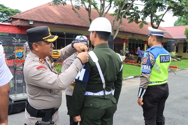 Kapolres Binjai memasangkan pita kepada personel Pom Binjai yang mengikuti Operasi Zebra Toba (Waspada/Ist).