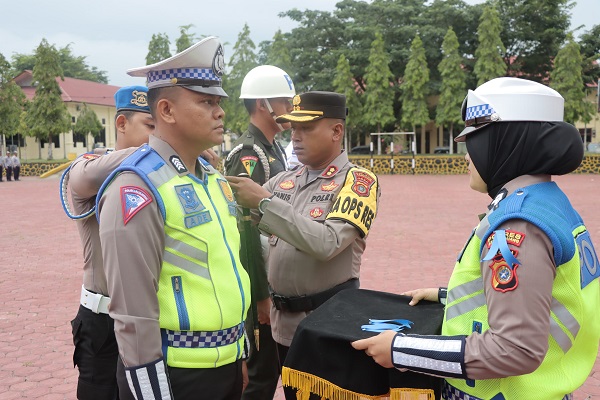 Kapolres Aceh Tamiang, AKBP Muhammad Yanis saat memasang pita secara simbolis kepada personel yang melaksanakan operasi Zebra Seulawah 2023 pada apel gelar pasukan yang berlangsung Senin (4/9) di Mapolres setempat.(Waspada/Ist).