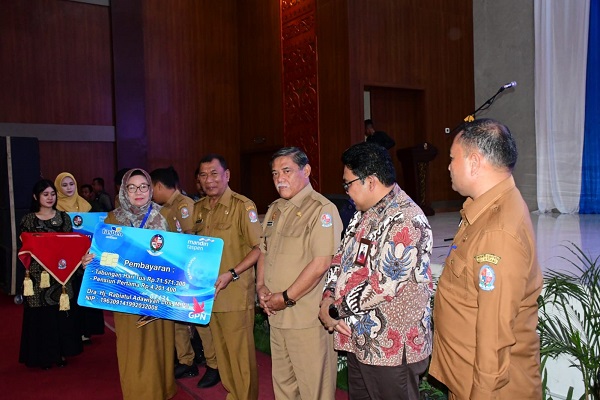 BUPATI Deliserdang H.Ashari Tambunan didampingi Wabup HMA Yusuf Siregar, Sekdakab H.Timur Tumanggor menyerahkan secara simbolis pembayaran Tabungan Hari Tua dari PT. Taspen kepada Dra.Hj.Rabiatul Adawiyah Lubis, MPd, di Convention Hall Pemkab Deliserdang, Senin (4/9).- (Waspada/Khairul K Siregar/B)