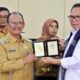 Wabup Simalungun H.Zonny Waldi memberikan Plakat Daerah kepada Ketua DPRD Sumut, Baskami Ginting, dalam rangkaian Kunker ke Simalungun, Senin (11/9).(Waspada/ist).