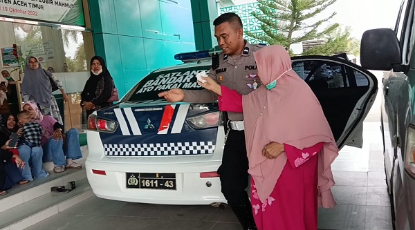 Aipda Ismanto, membantu salah seorang ibu-ibu yang mengeluh sesak nafas ke RSUD Dr Zubir Mahmud Aceh Timur di Idi, Selasa (12/9). Waspada/Muhammad Ishak