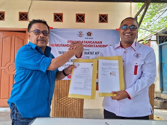 Ketua PWI Aceh, Nasir Nurdin bersama Ketua YARA, Safaruddin memperlihatkan dokumen MoU bantuan pendidikan dan hukum usai penandatanganan, Rabu (20/9) di Banda Aceh. (Waspada/Muhammad Zairin)