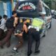 Kanit Turjawali Sat Lantas Polres Pematangsiantar Ipda P. Manurung bersama para pelajar penumpang mobil minibus Angkot mendorong Angkot yang mogok saat berhenti di lampu merah  Apil, Jl. Kartini, Sabtu (2/9) ke tempat yang tidak mengganggu lalu lintas.(Waspada-Ist). 