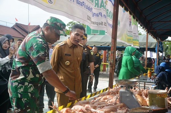 Pj Wali Kota Langsa, Syaridin didampingi Dandim 0104/Aceh Timur Letkol Inf. Tri Purwanto, saat membuka pasar murah bagi warga di Stadion Langsa, Senin (25/9). Waspada/Rapian